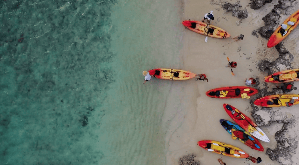 People launching kayak rentals from Active Oahu into the ocean at Kailua Beach